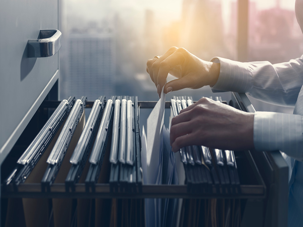 office worker looking through a filing cabinet